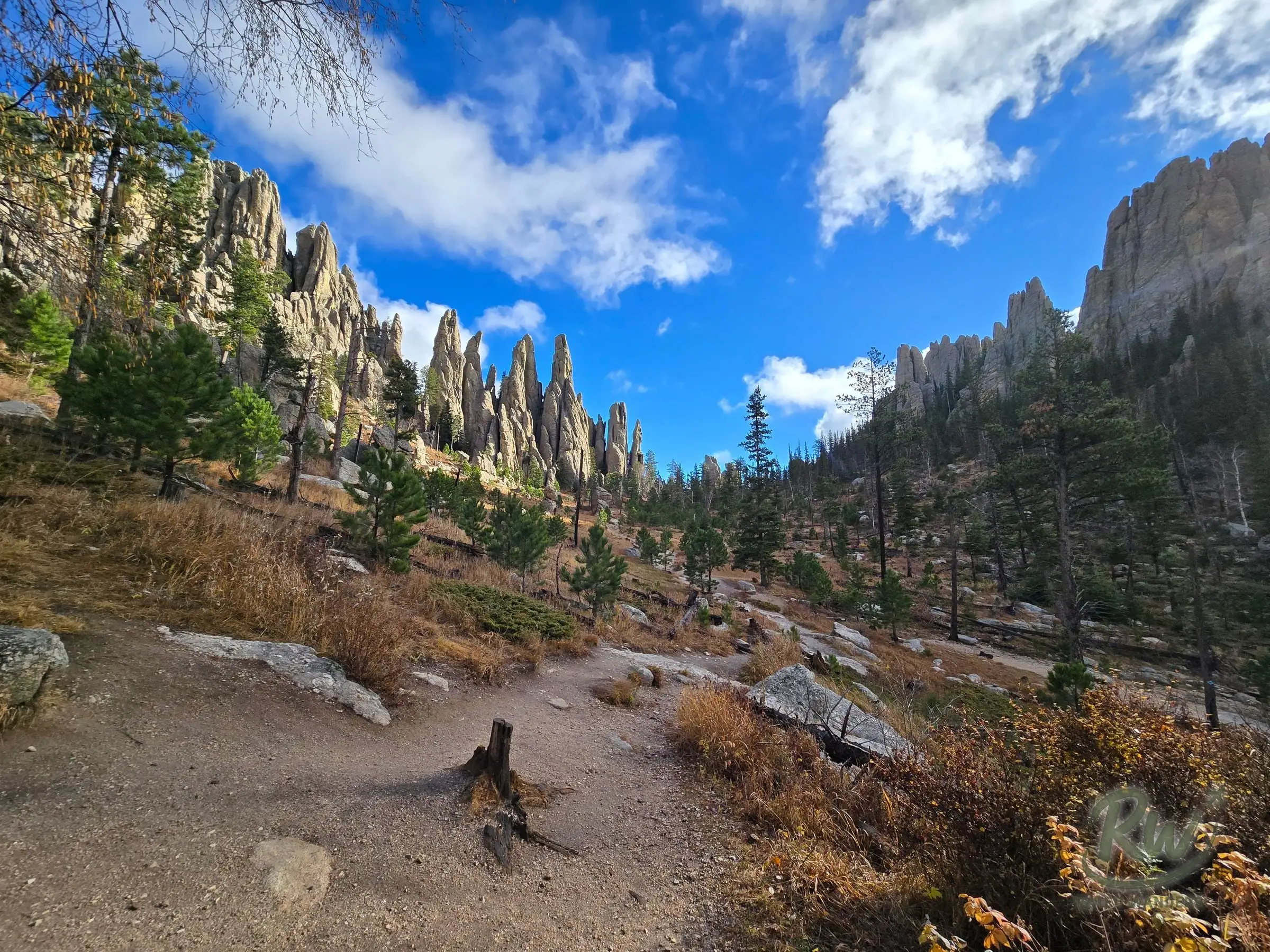 A wide view along the trail, granite spires lining both sides of a pine valley