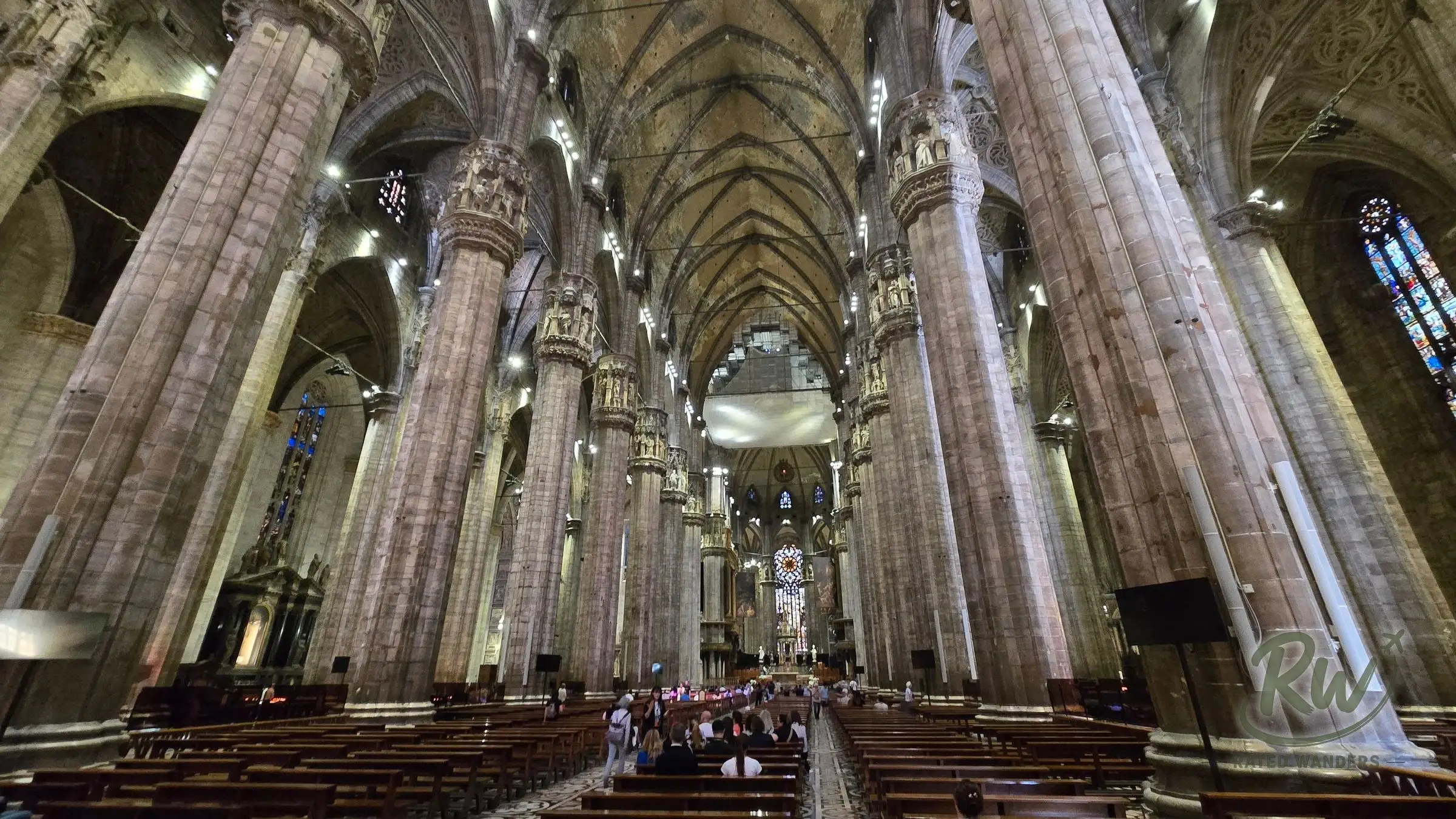 The long nave of the Duomo lined with massive stone columns under a vaulted ceiling
