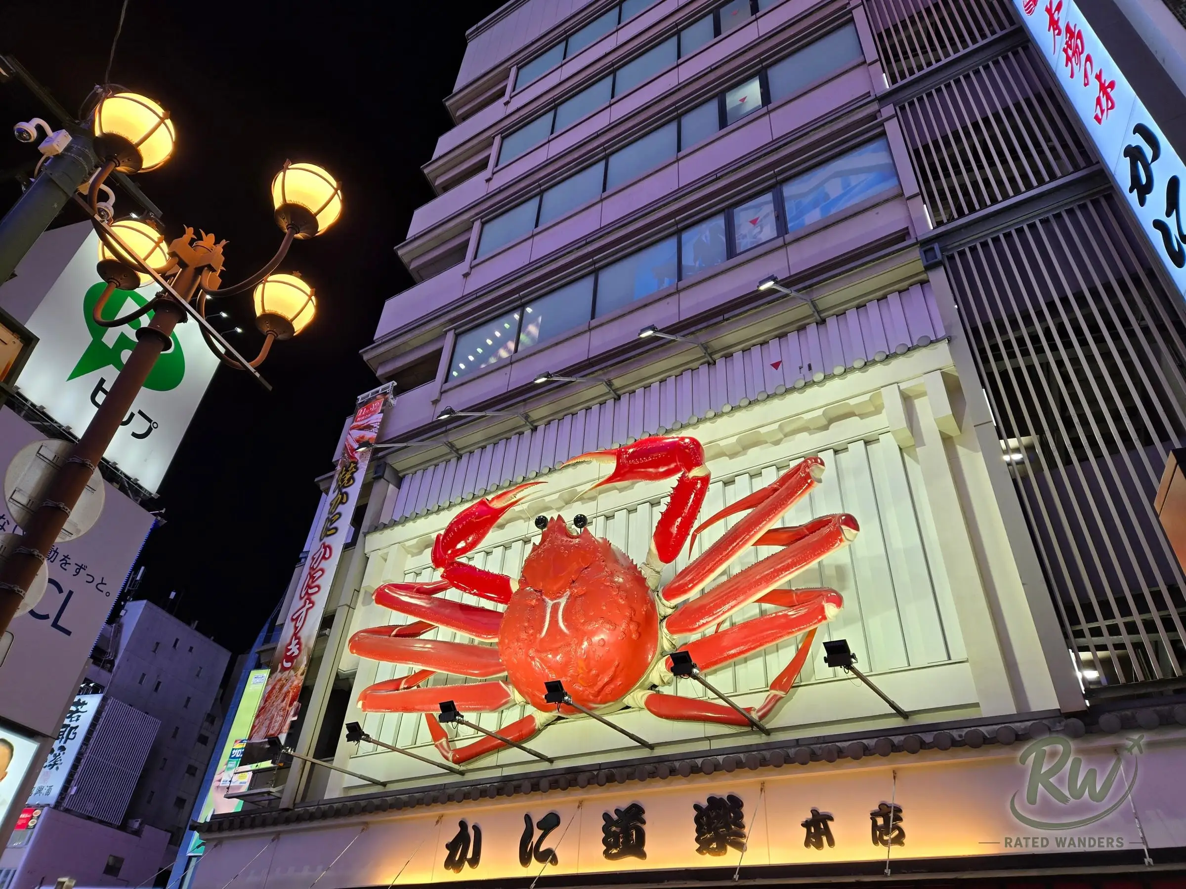 A giant mechanical red crab sign above a restaurant entrance at night