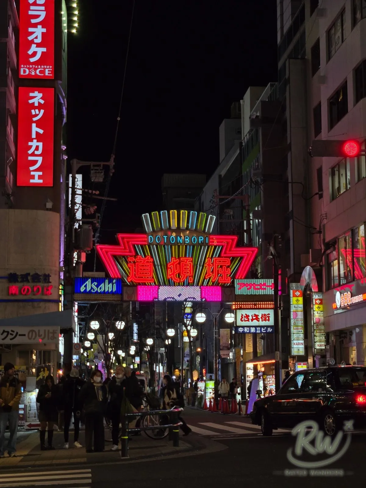 The neon Dotonbori gate sign glowing over the street at night