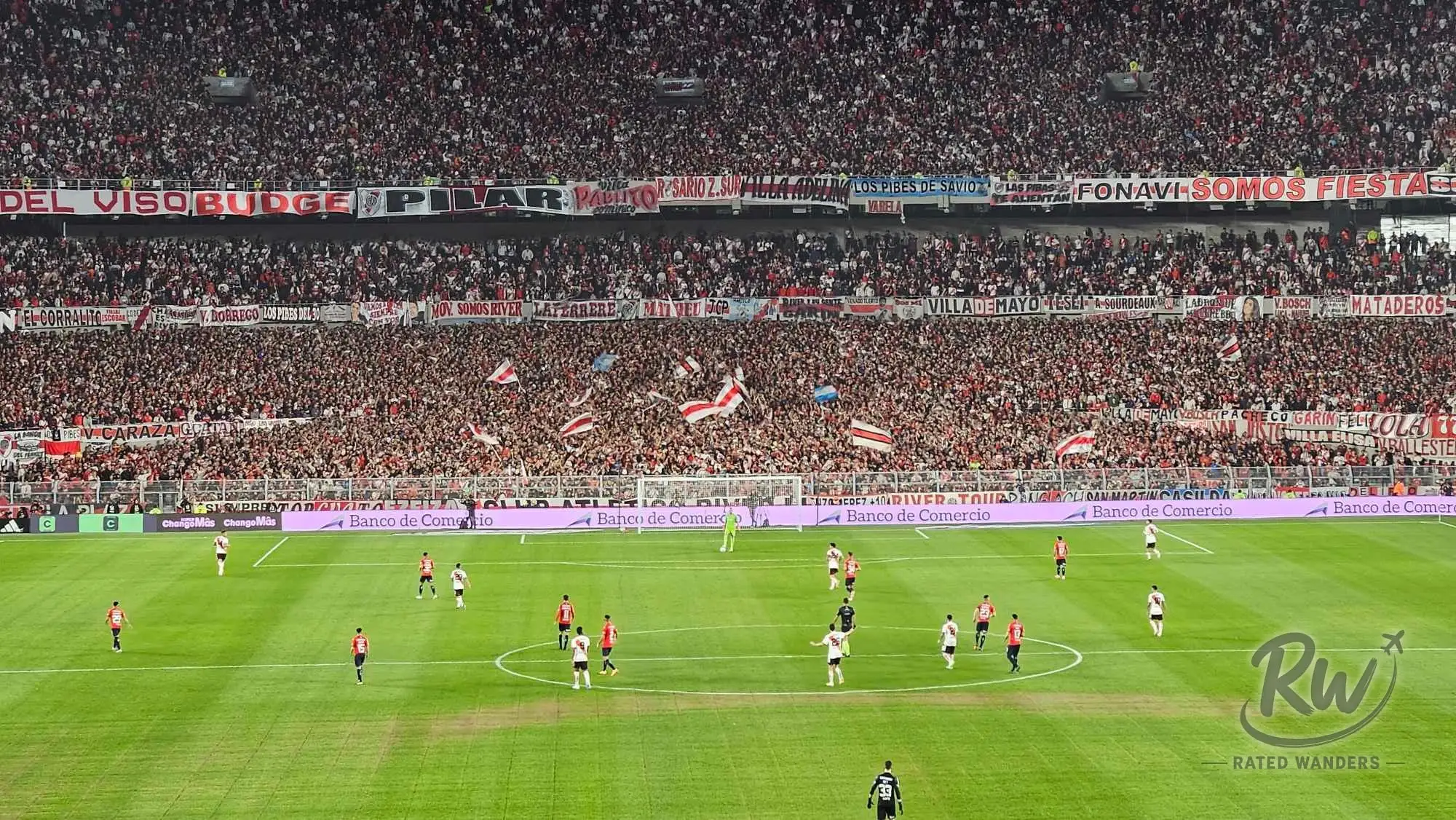 A stand packed end to end with River Plate supporters waving flags during the match
