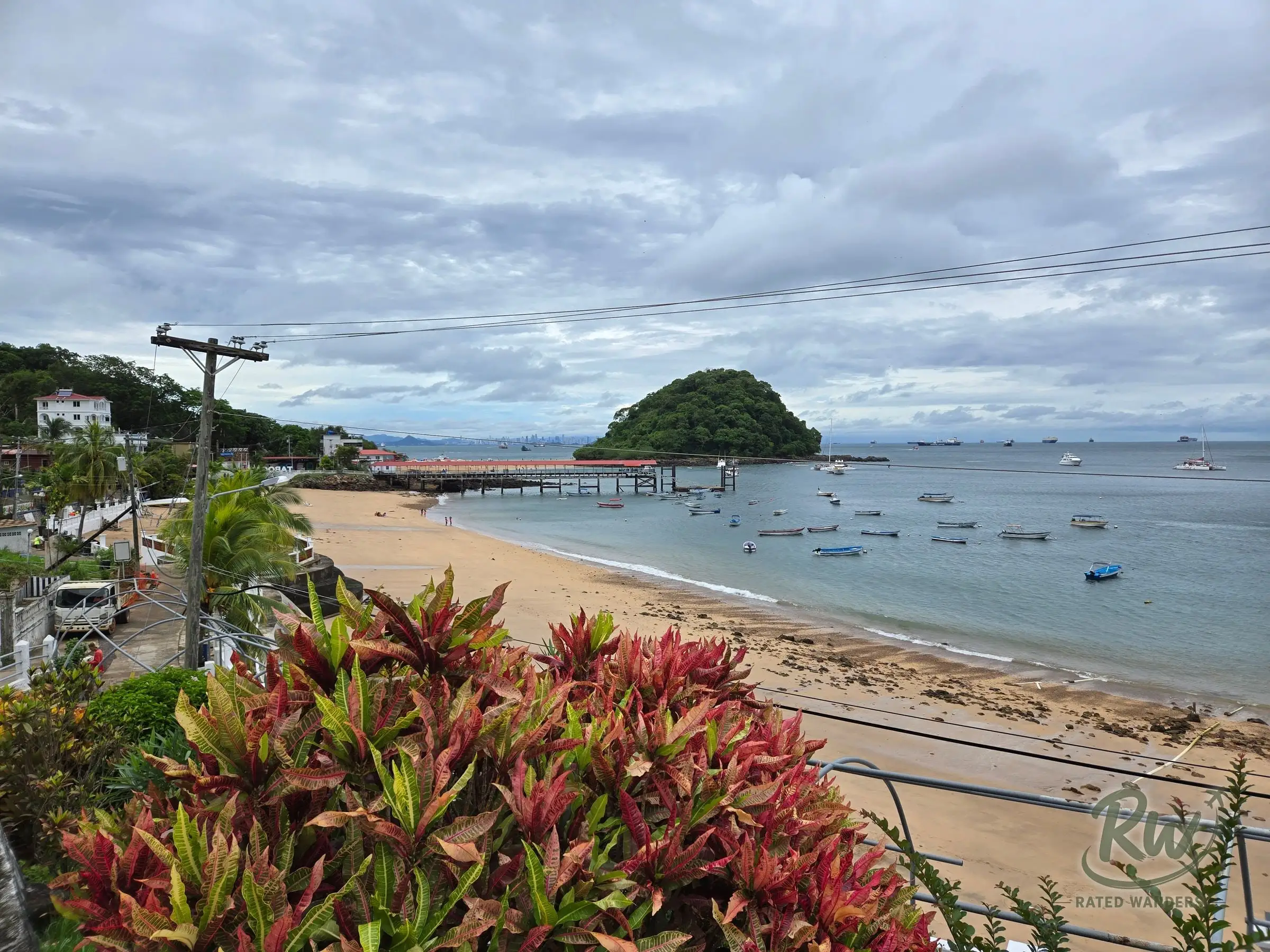 Playa Honda seen from above the road, small boats moored off the pier and the Panama City skyline faint on the horizon